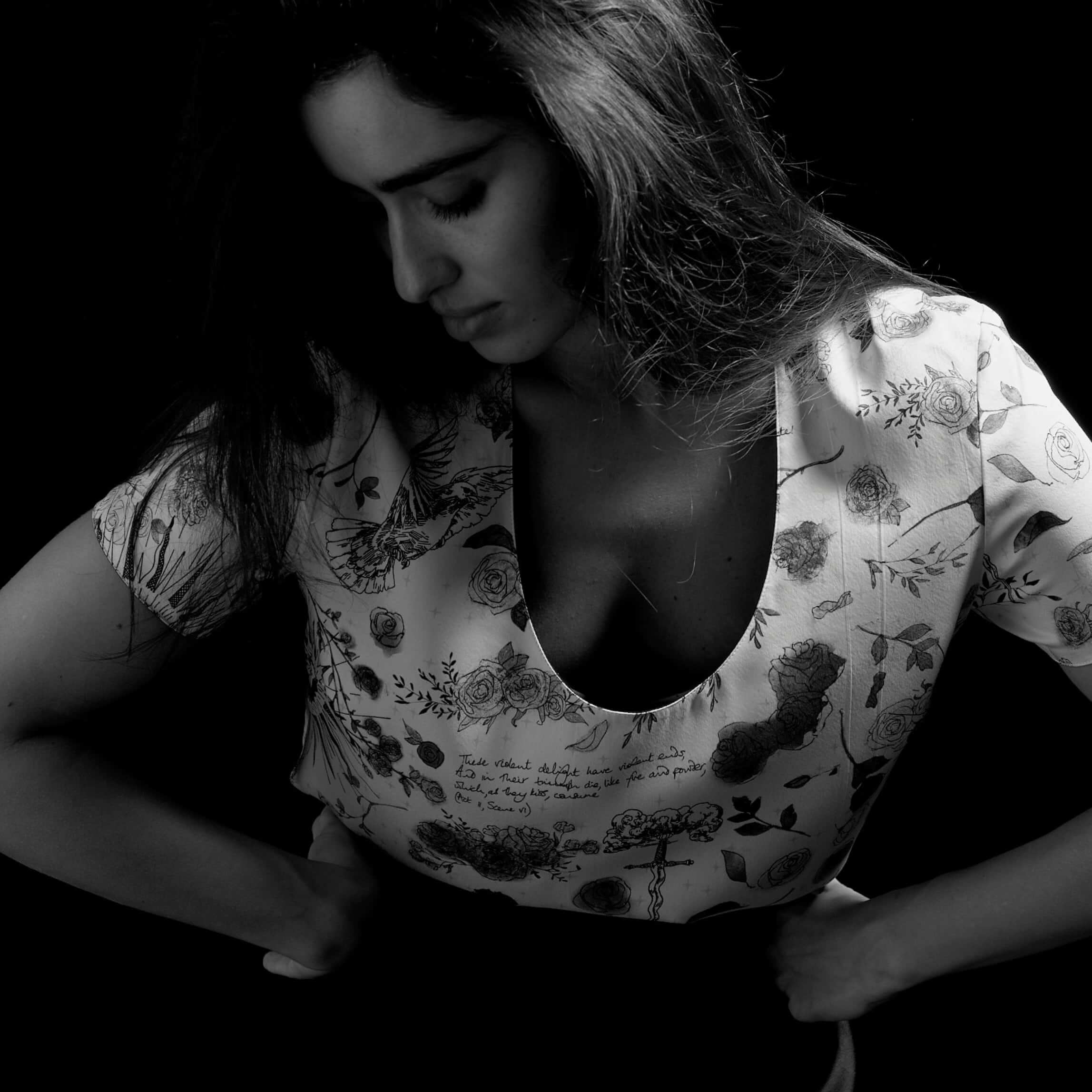 Dramatic black and white portrait of a woman wearing The Romeo Tee, featuring the hand-drawn Aubade Print.